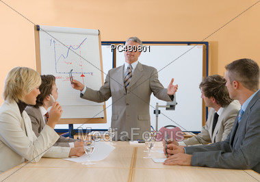 Business People Sitting at Conference Desk Stock Photo