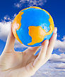 Stock Photo : Sunlight Pictures: Earth W In Hand Against The Blue Sky