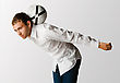 Man Dressed In A White Shirt And Blue Jeans Balances A White Football On The Back Of His Neck As He Leans Forward - stock photography