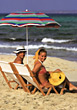 Man and woman sitting in beach chairs smiling