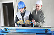 Stock Photo : Centre Stock Photography: Two Men Operating Machine Than Cuts Sheet Metal