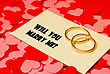 Stock Photo : Married Stock Image: Two Rings And A Card With Marriage Proposal On The Red Background