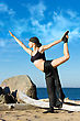 Young Beautiful Woman Is Making Yoga Exercises On The Beach