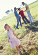 Stock Photo : Children Stock Image: Young Girl Standing In Fields, Family In Background